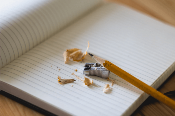 Sharpening a pen to write in a notebook.
