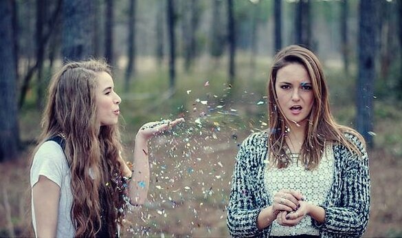 Two girls are blowing glitter: friendship at first sight.