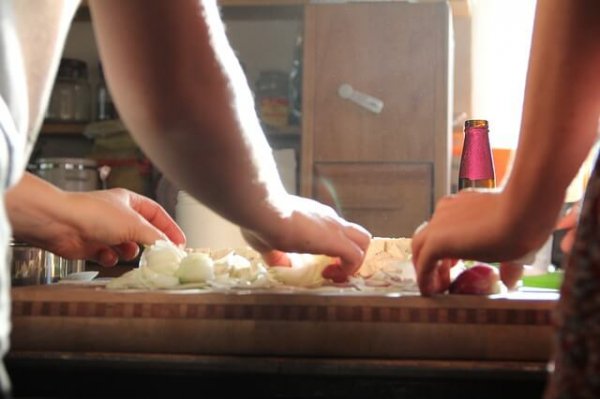 Cooking together, chopping onions.
