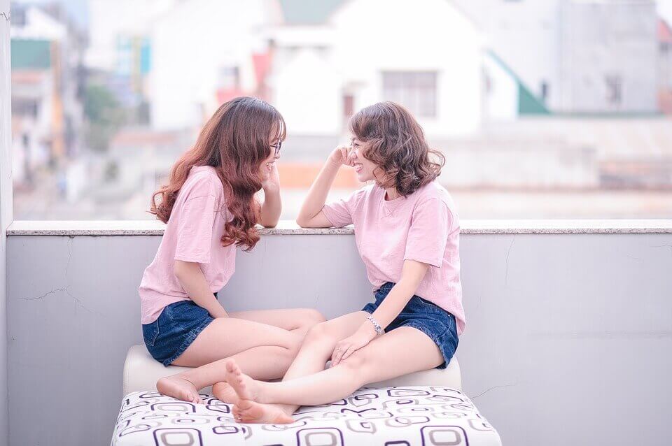 Two women are talking while wearing matching outfits.