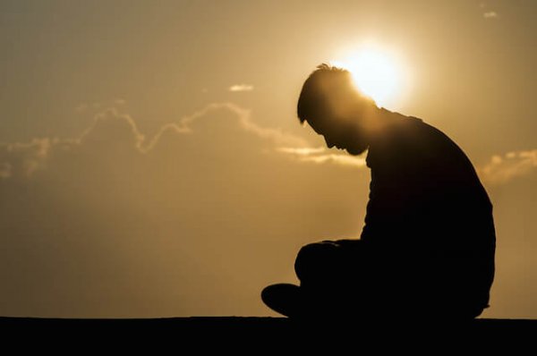 Silhouette of an upset man at sunset.
