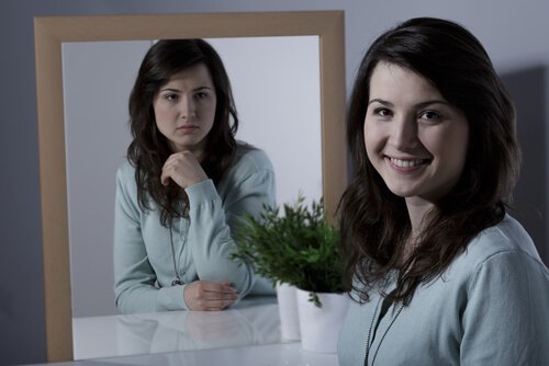A woman with cyclothymic disorder at the mirror, happy and sad.