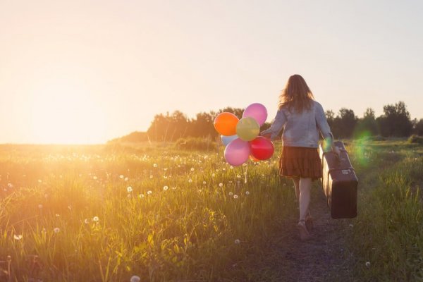 Woman with case and balloons
