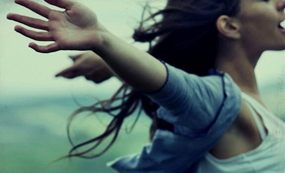 A woman has her arms outstretched.