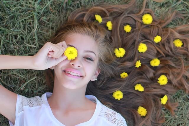A female teenager has a flower over her eye.