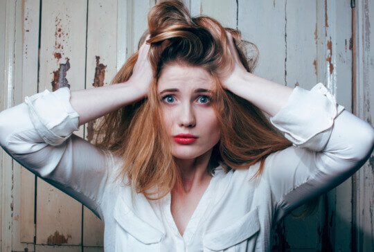 A woman with messy hair is stressed.