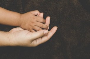 adopted child holding mother's hand