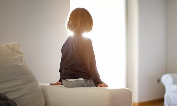 child with reactive attachment disorder sitting alone on the couch