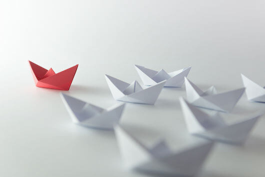 red paper boat symbolizing leadership as a social identity