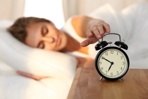 woman turning off her alarm clock