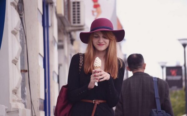 A girl looking happily at an ice cream cone.