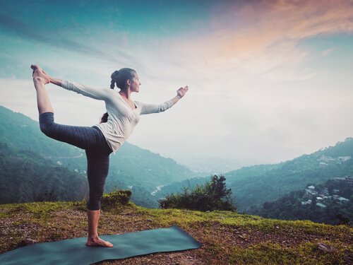 A woman doing yoga outdoors.