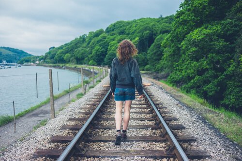 Missed opportunity, a woman walking on the train tracks.