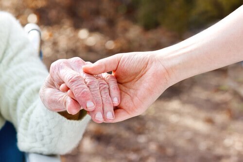 someone holding the hand of a person with Alzheimer's