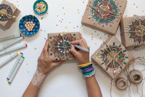 girl drawing mandalas onto wrapped gifts