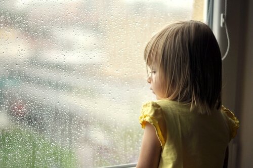 girl looking out the window as a symbol of emotional wounds from the past