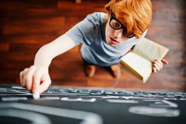 intelligent guy with doubts writing on a blackboard