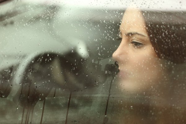woman looking out of car window using emotional reasoning to think about someone far away