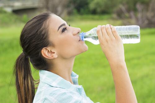 Woman drinking water to prevent headaches 