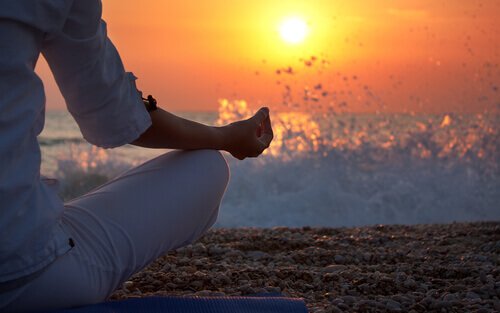 Meditation in front of a sunset to prioritize