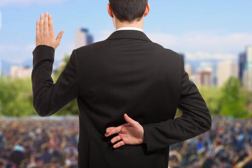 Politician crossing fingers behind his back.