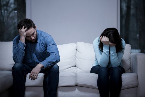 Angry couple on couch symbolizing staying in a relationship you don't want to be in.