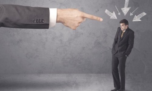 Businessman pointing the finger at his employee.