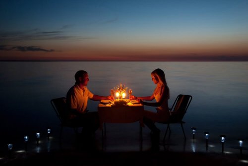 par, der spiser romantisk middag ved vandet