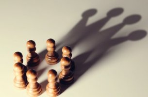 Chess pieces forming a shadow in the shape of a crown.