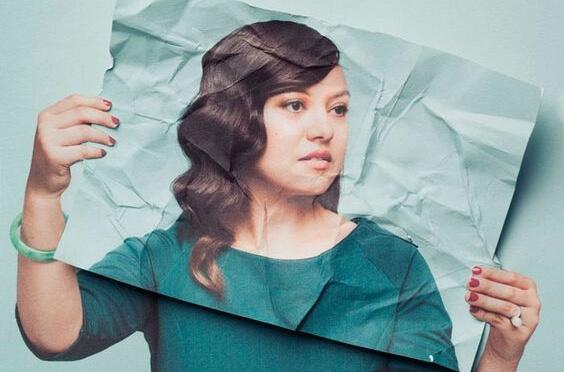 Woman holding her face on a paper.