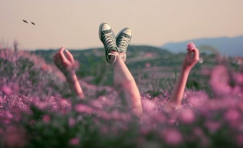 Girl in field of flowers feeling happiness.