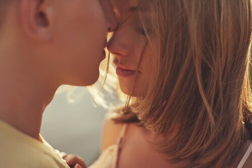 A couple shows affection by kissing each other.