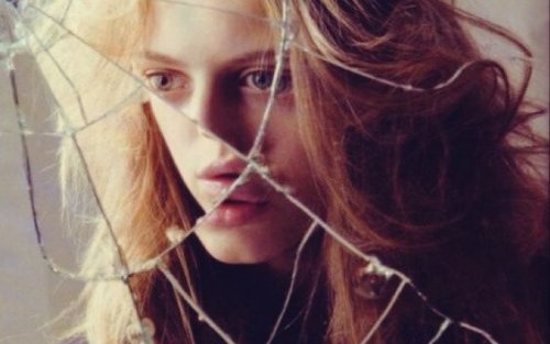 Reflection of a girl in a broken mirror.