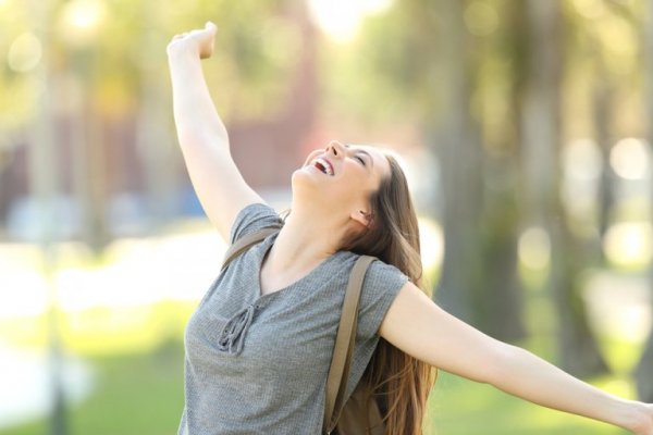Girl with high self esteem stretching out her arms in happiness.