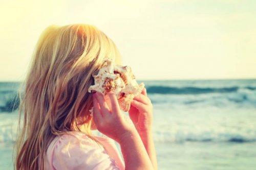 Selective attention shown through a girl listening to a shell at the beach.