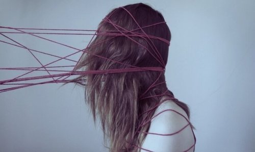 Cognitive biases wrapping a girl's head like threads.