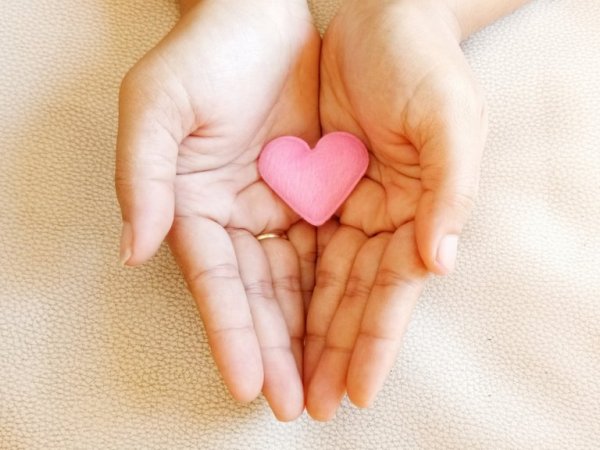 Hands holding a heart.