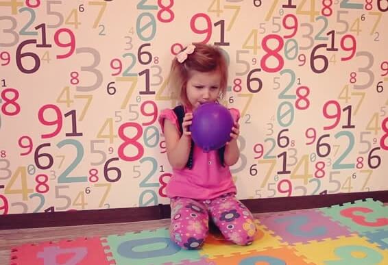 Little girl practicing balloon breathing.
