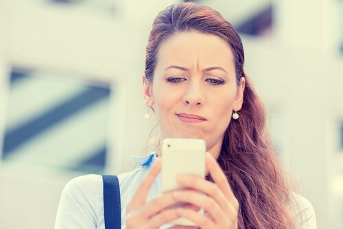 kvinde der kigger skeptisk på sin mobil