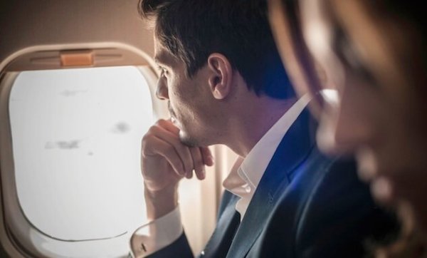 Man looking out airplane window.