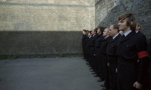 A Clockwork Orange still of men against a wall.