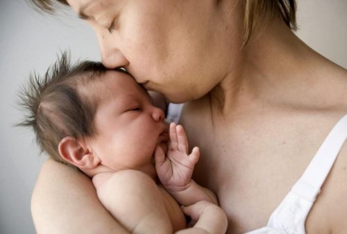 Mom kissing baby's forehead.