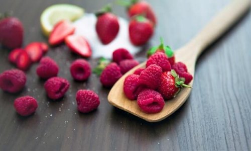 Raspberries and strawberries on a spoon.