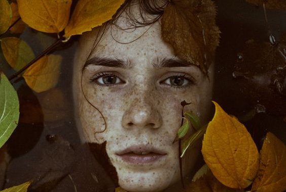 A woman with leaves around her head.
