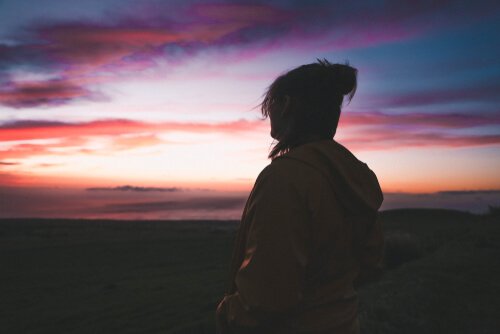 Sad person feeling alone looking out at nature.
