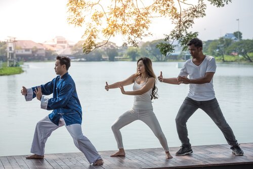 Three people doing qigong.
