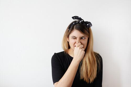 Woman with olfactory reference syndrome covering her nose.