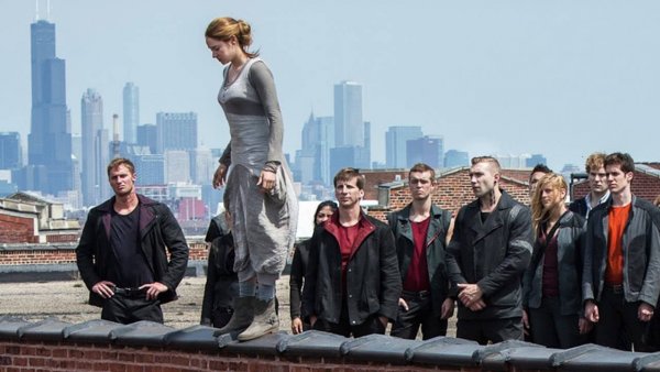 tilskuere der kigger på en kvinde der står på kanten af en mur