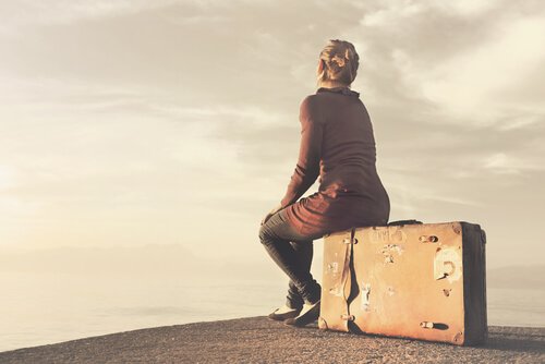 Woman sitting on a suitcase.