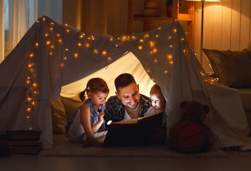 A dad strengthening his relationship with his kids by reading to them.
